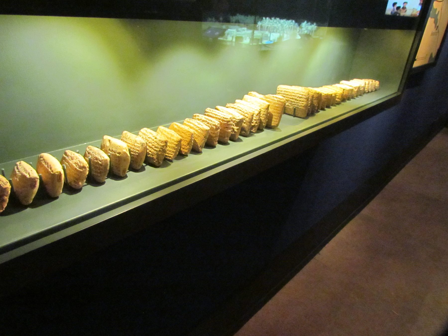 Clay cuneiform tablets with inscriptions arranged in a museum display case.