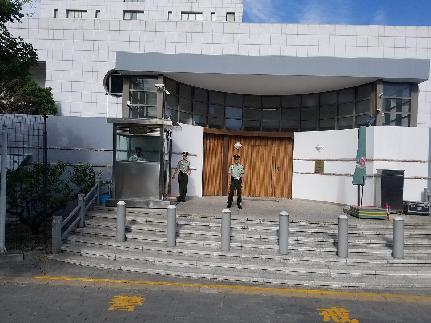 Exterior of the Embassy of Israel in Beijing, a modern building with security bollards and the embassy entrance visible.