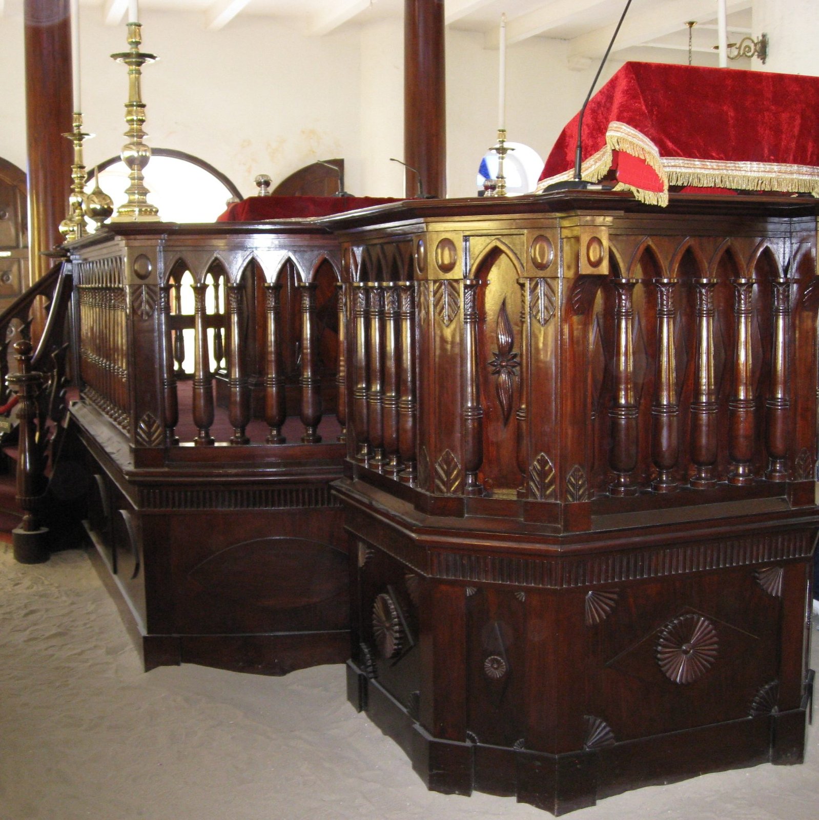 Interior of the Mikvé Israel-Emanuel synagogue in Willemstad, Curaçao, with the dark mahogany bimah and benches set above its famous white sand floor