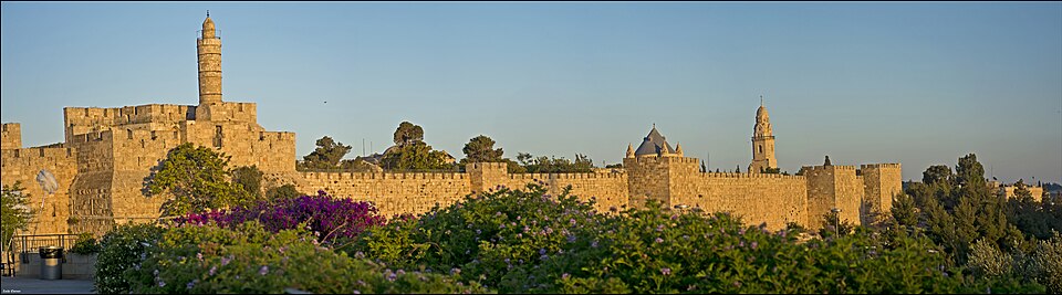 Panorama of Jerusalem's Old City at golden hour: the Tower of David citadel, the ramparts and Mount Zion.