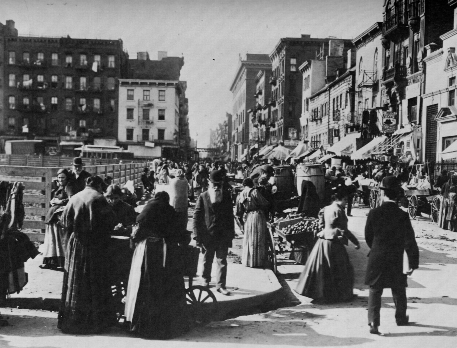 A crowded Lower East Side street lined with tenements, pushcarts and shoppers