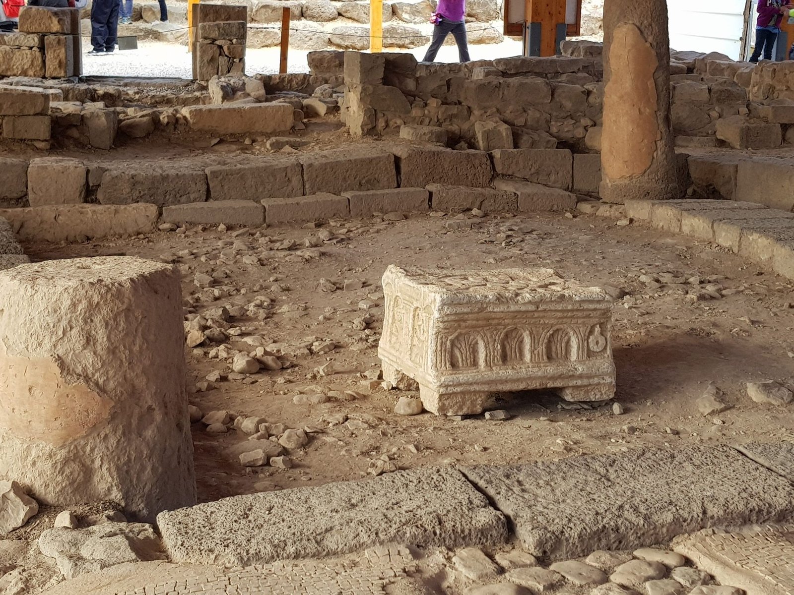 The carved Magdala Stone standing on the floor of the excavated first-century synagogue at Magdala, its arcaded side facing the camera
