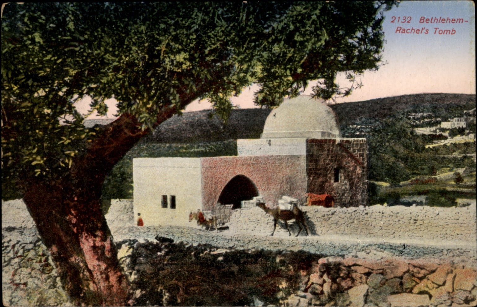 The whitewashed domed shrine of Rachel's Tomb on the Bethlehem road, with arched entrance and surrounding arid landscape.