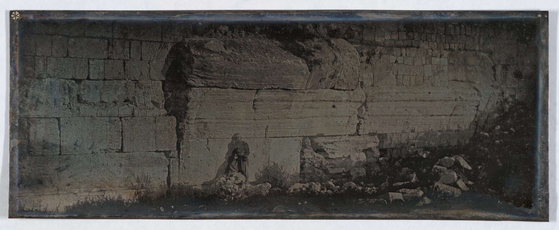 Ancient limestone ashlar blocks of Robinson's Arch springer course on the southwest wall of the Temple Mount, Jerusalem, with excavated Herodian street and pier base below