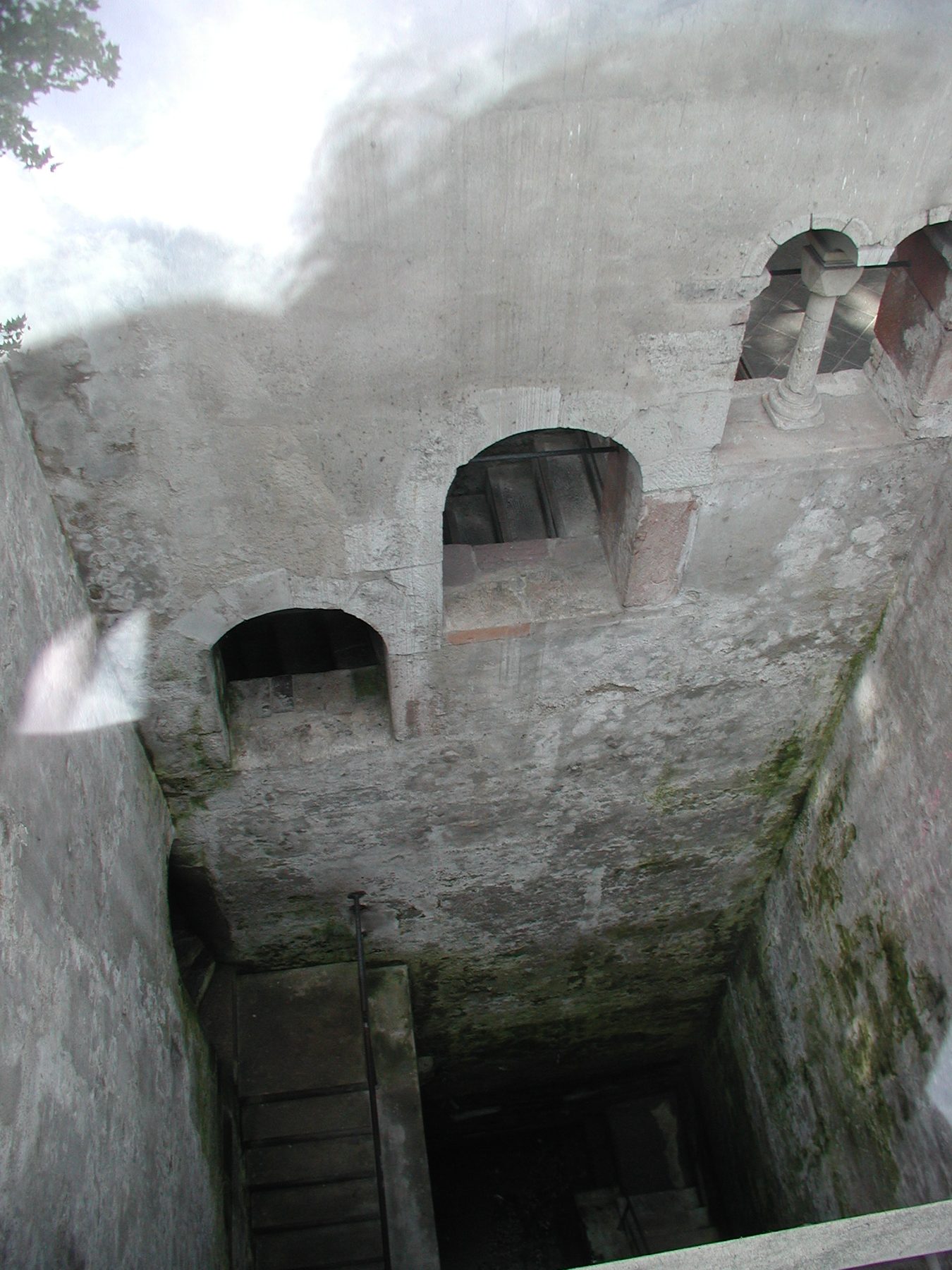 Underground stone-lined chamber of the Cologne mikveh with arched openings and stepped descent to groundwater level
