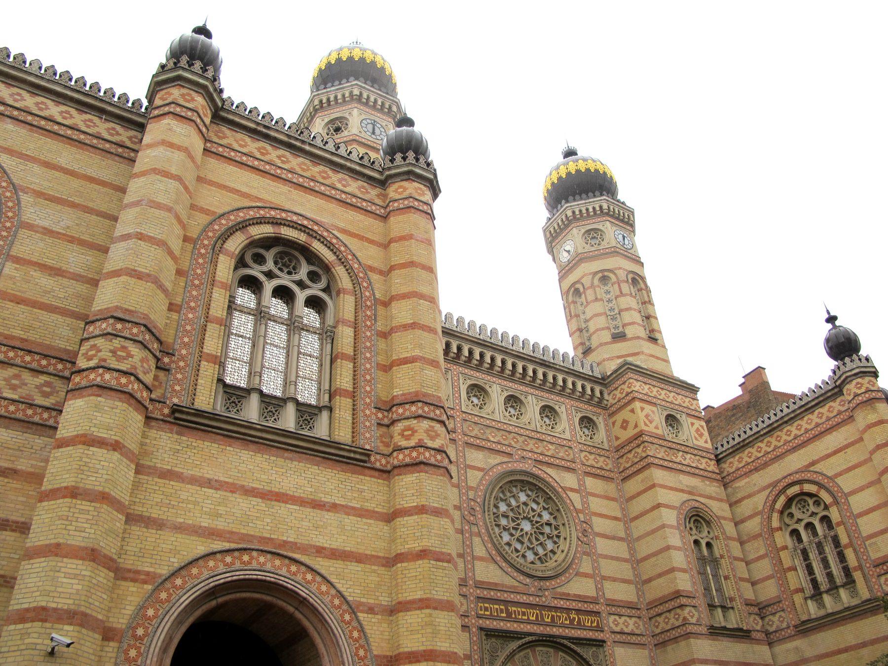Twin towers with golden domes and striped brick facade of the Dohany Street Synagogue in Budapest
