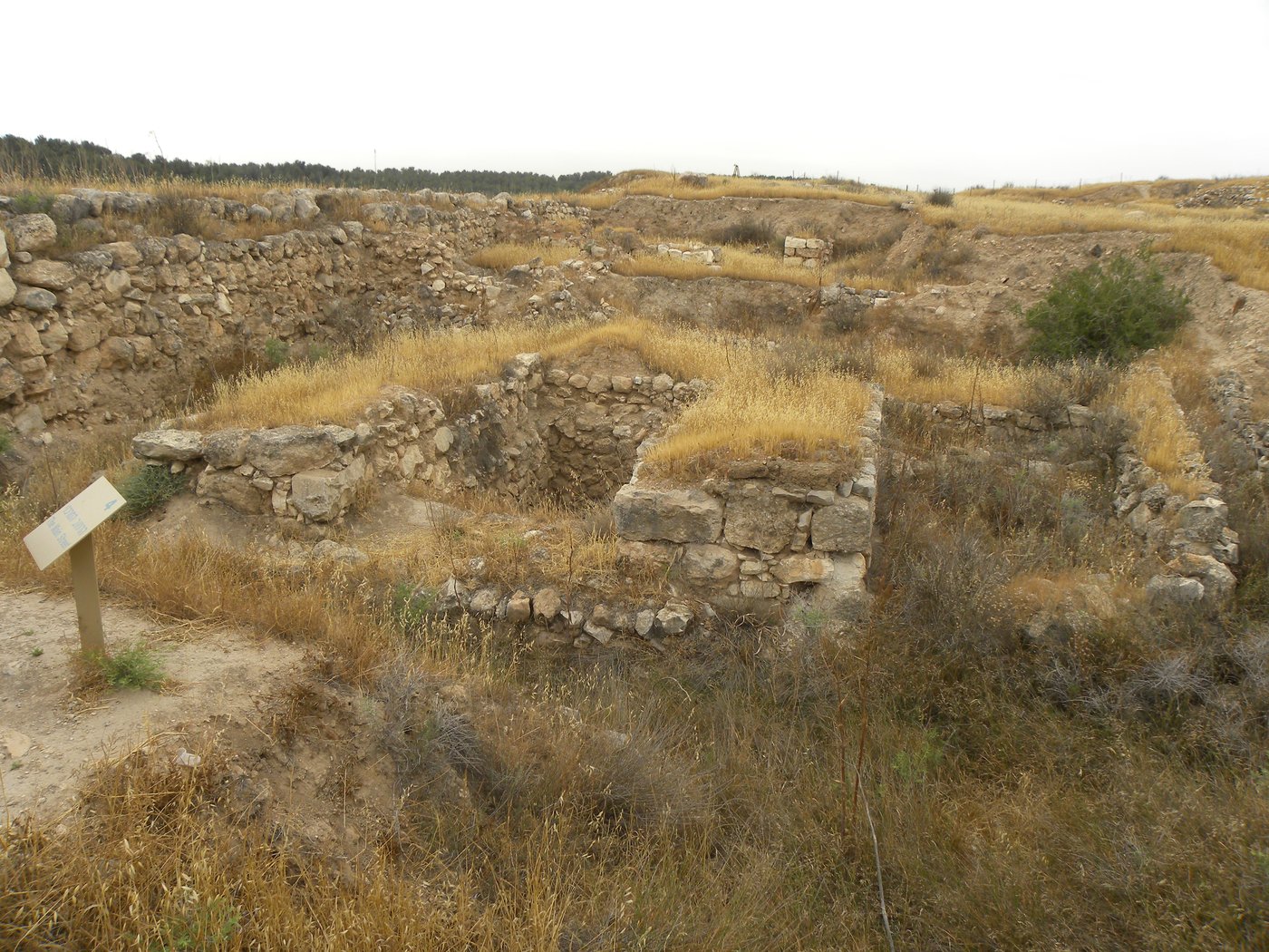 The excavated stone foundations of an ancient multi-chambered city gate.