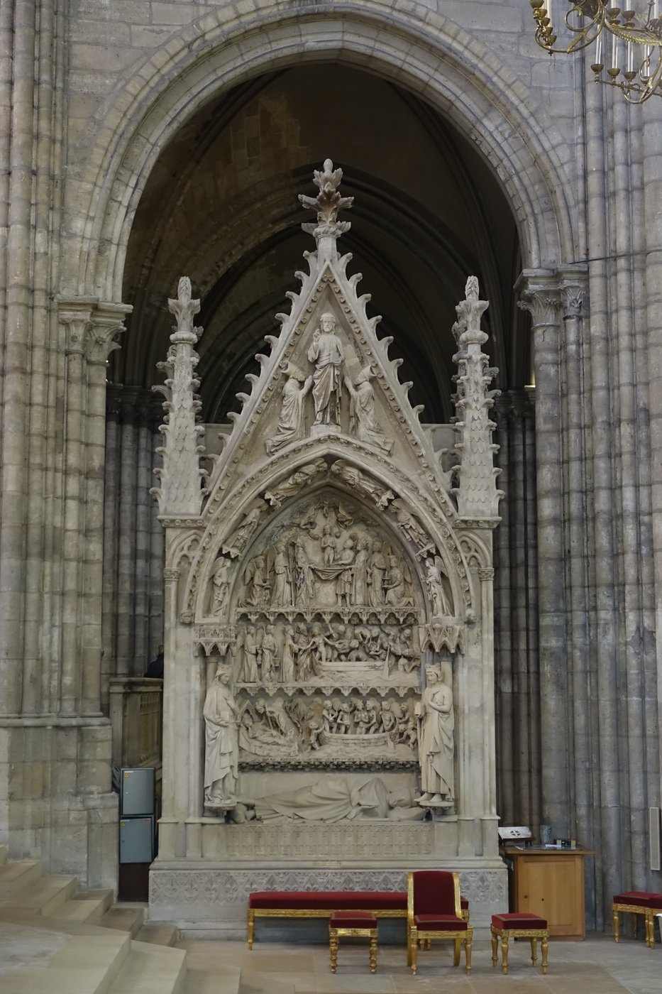 Carved Gothic stone tomb monument with a reclining royal effigy.