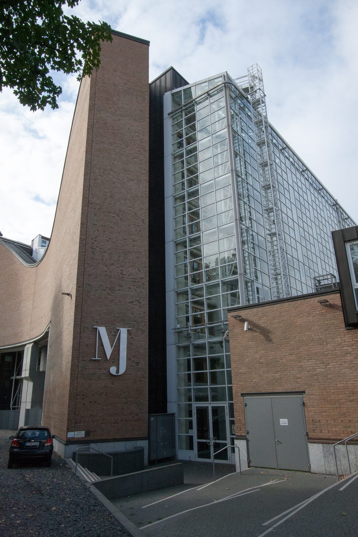 Exterior of the Museum Judengasse in Frankfurt, showing the modern museum building with glass and brick construction and the 'MJ' sign identifying the museum.