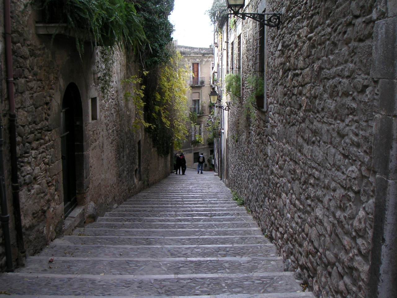 Stepped stone lane between medieval stone buildings, Girona's Call