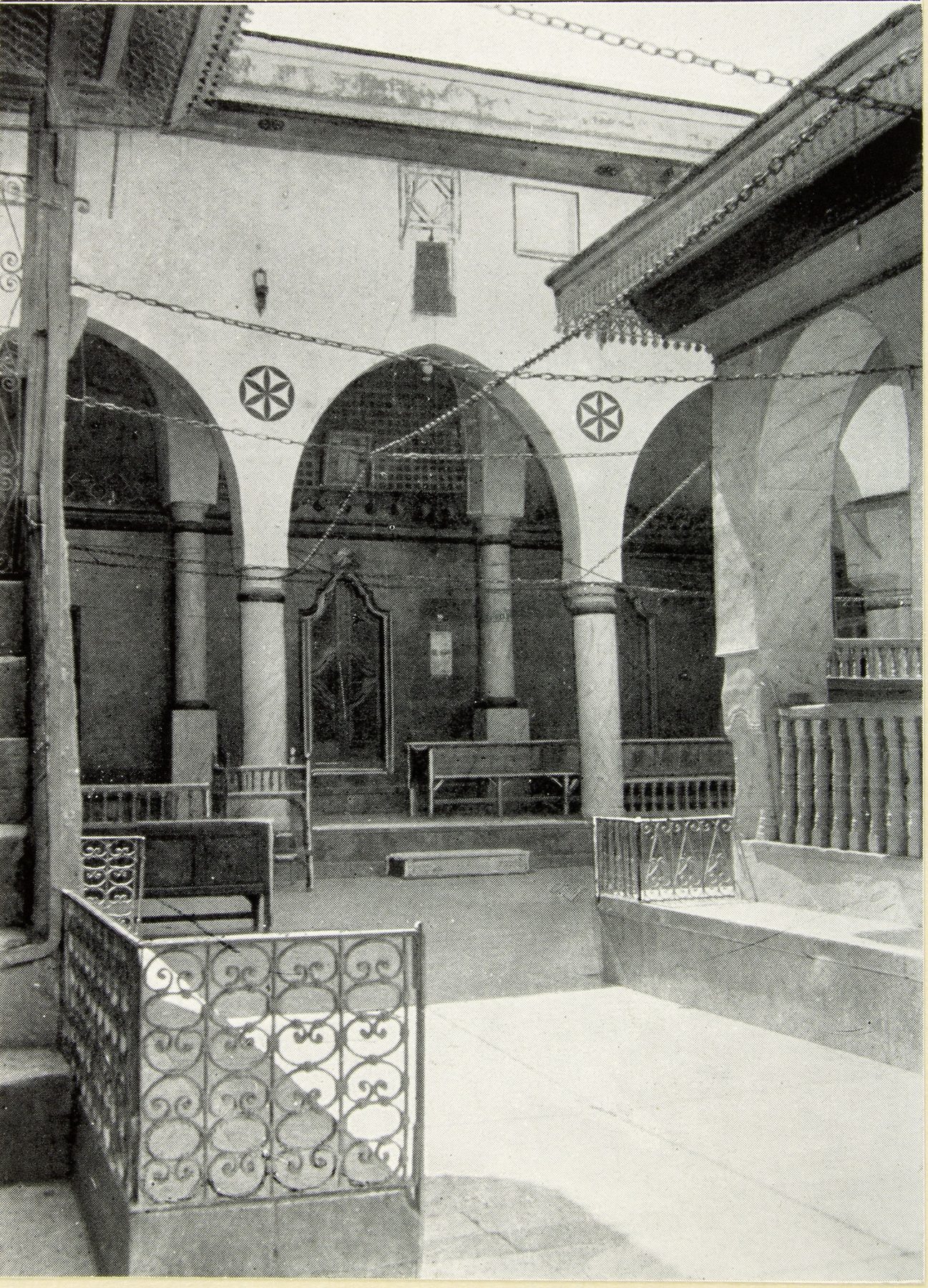 Interior courtyard of the Great Synagogue of Aleppo showing arched stone arcades and ornamental railings before the 1947 fire