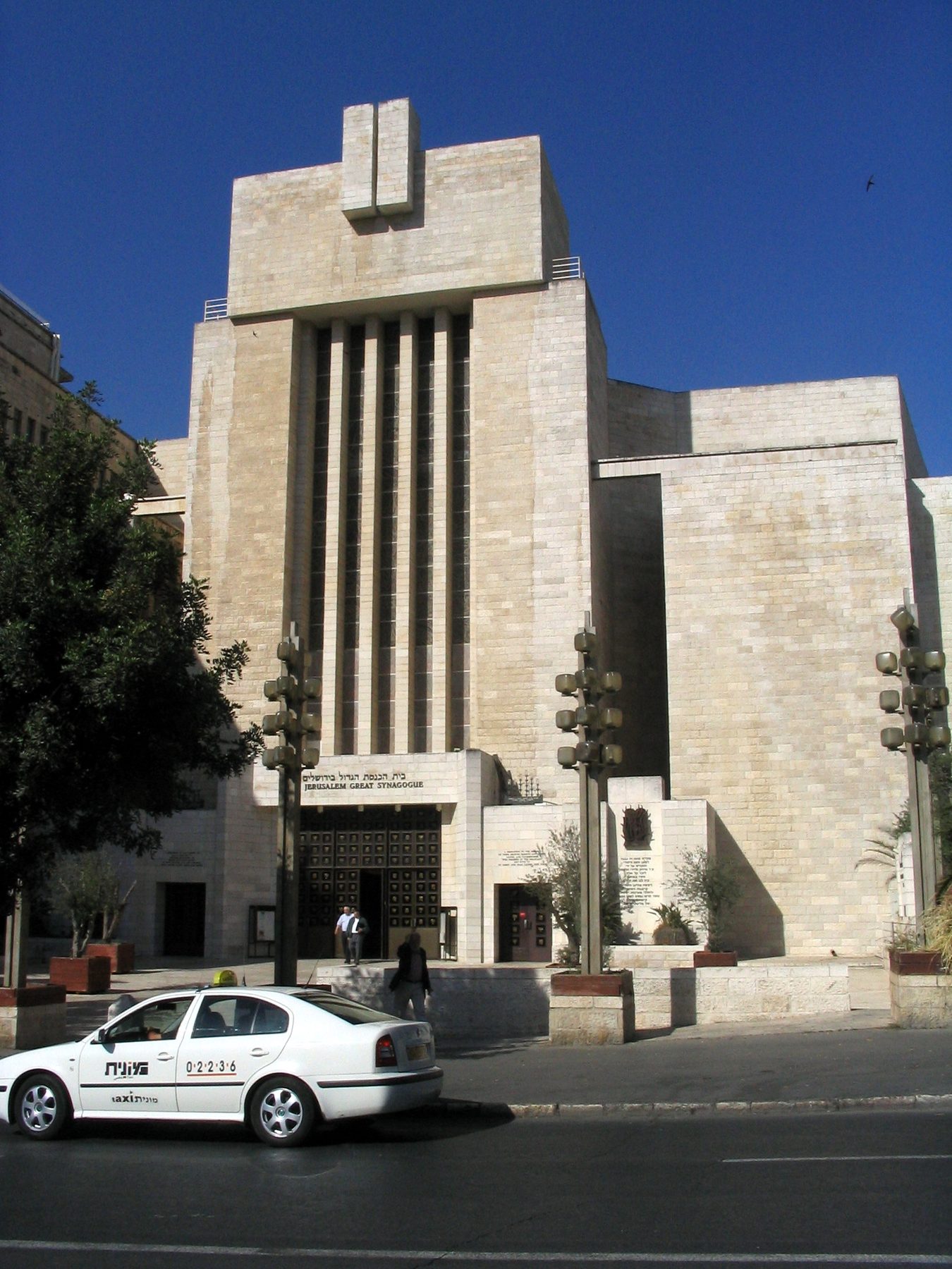 Facade of the Great Synagogue of Jerusalem showing modernist stone architecture with vertical fluting and geometric details