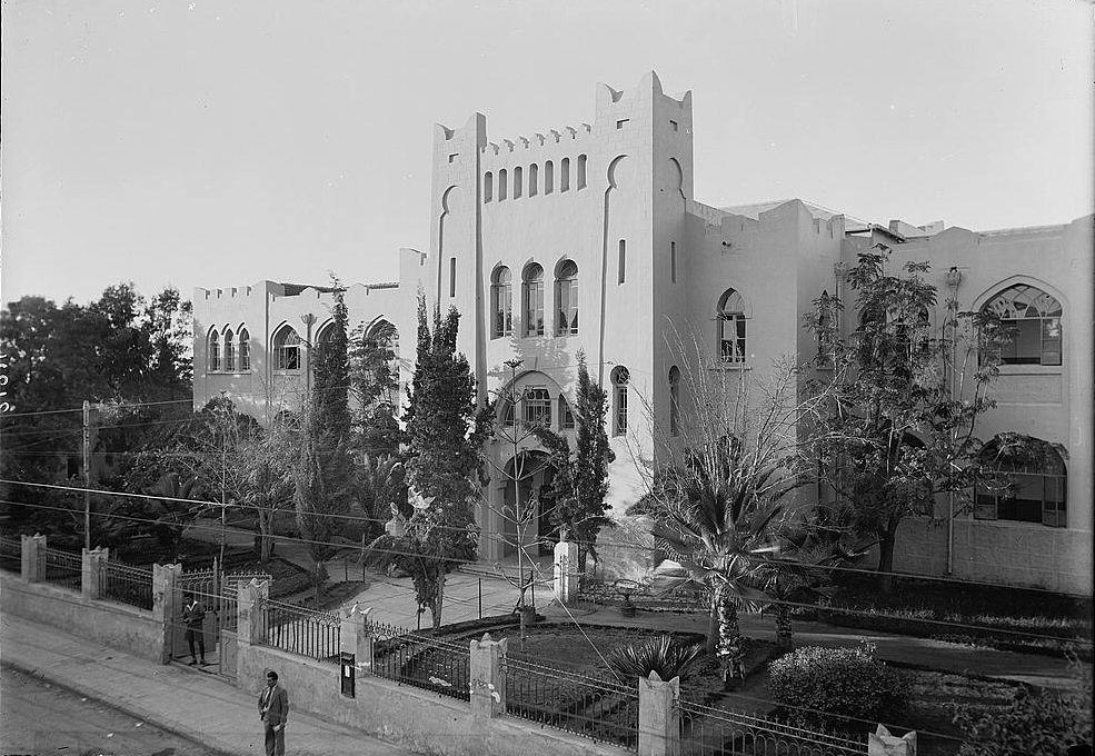 The Herzliya Hebrew Gymnasium in Tel Aviv, with Temple-fronted facade and corner turrets.