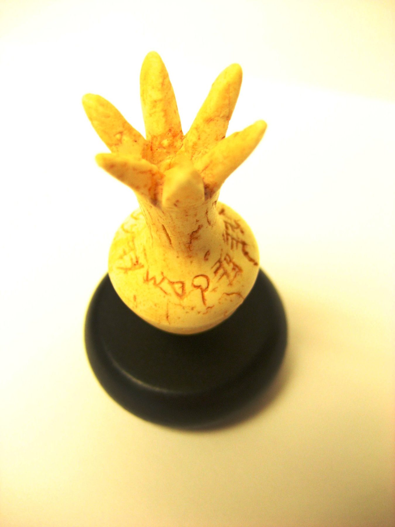 Pale ivory pomegranate finial with five segmented lobes and incised paleo-Hebrew inscription on the body