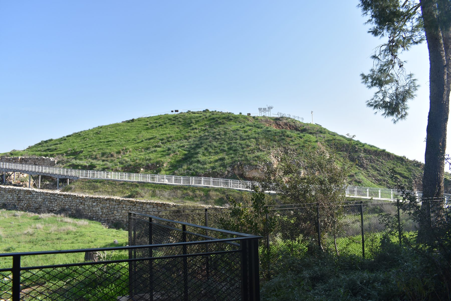 Tel Lachish with the Assyrian siege ramp visible as a mound of exposed stone and earth on the tell's southwestern slope.
