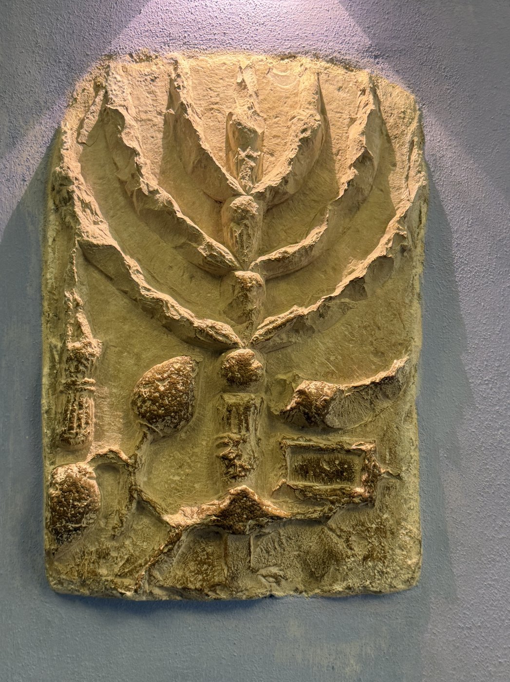 Ancient carved stone showing a menorah and ritual symbols