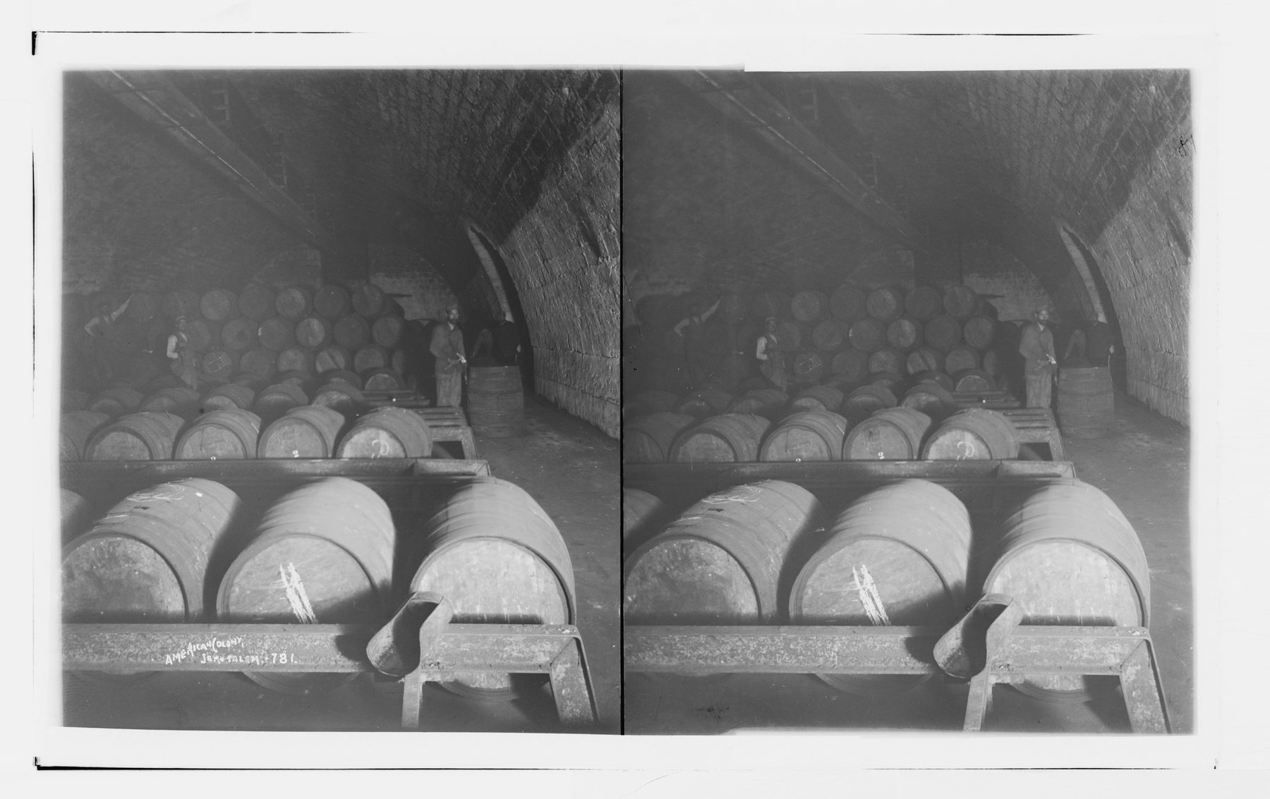 Wine barrels arranged in rows within a vaulted stone cellar