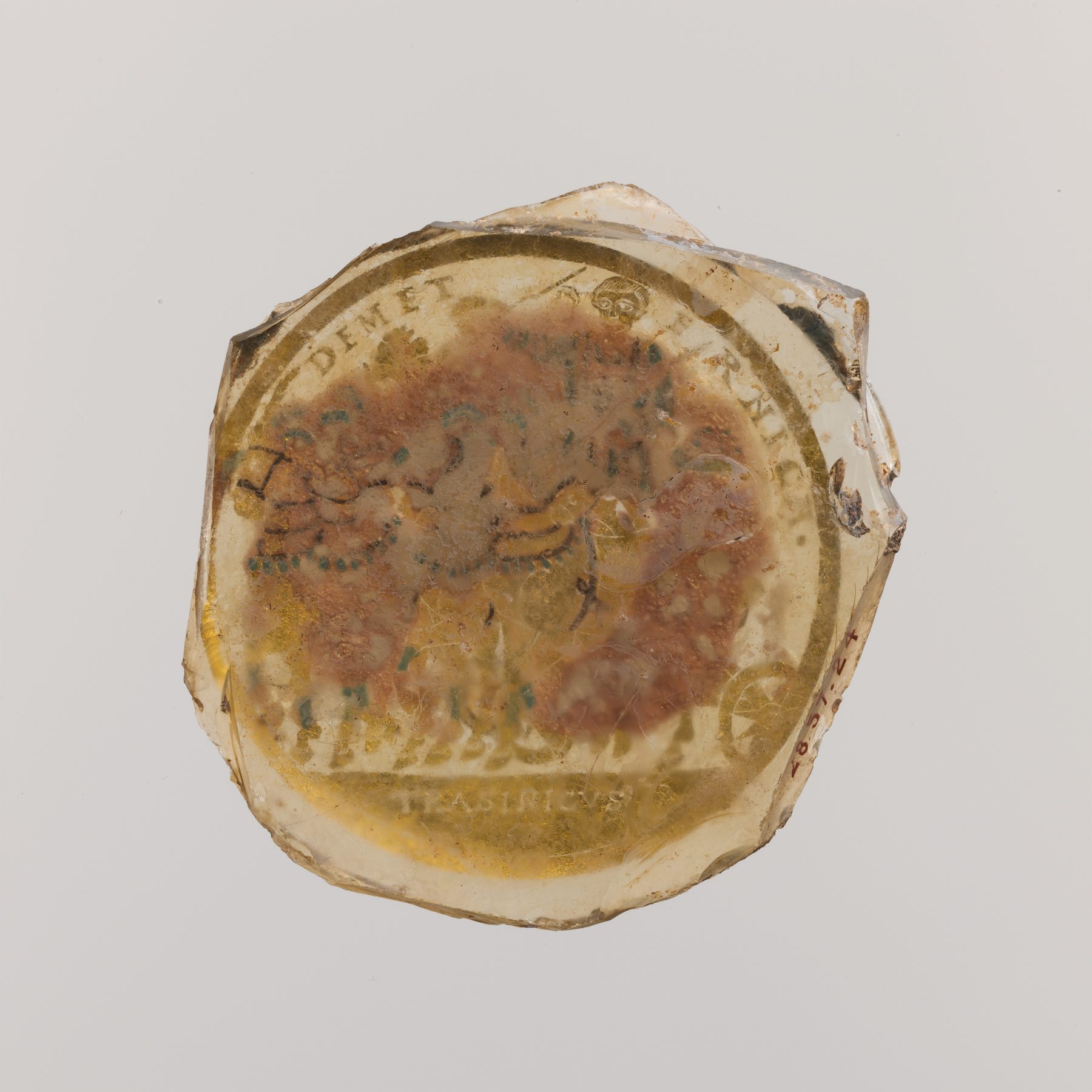 Base of a Roman glass beaker with gold leaf decoration and lettering sealed between two layers of fused glass