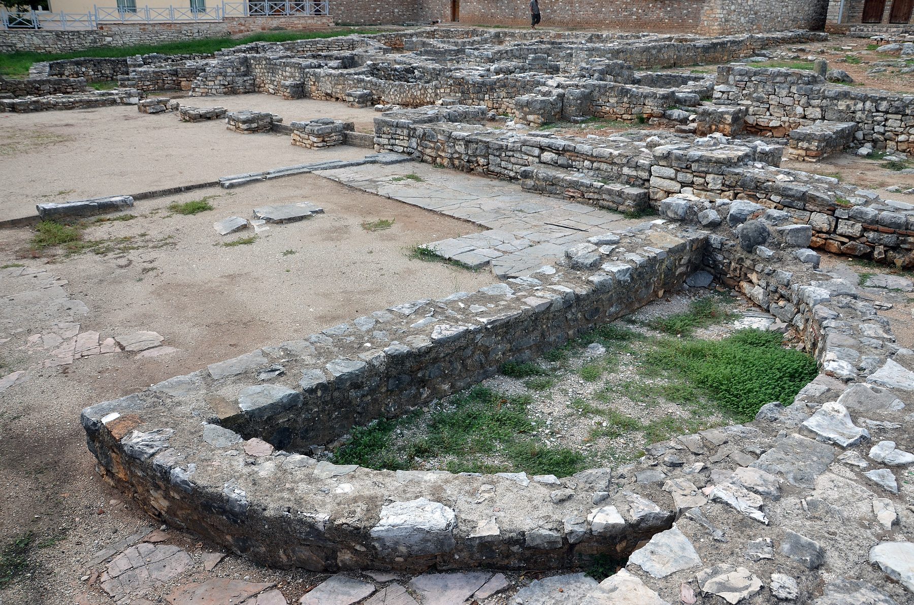 Excavated stone foundations and walls of the Saranda Synagogue, showing rectangular structure with laid stone blocks on the archaeological site in Albania.