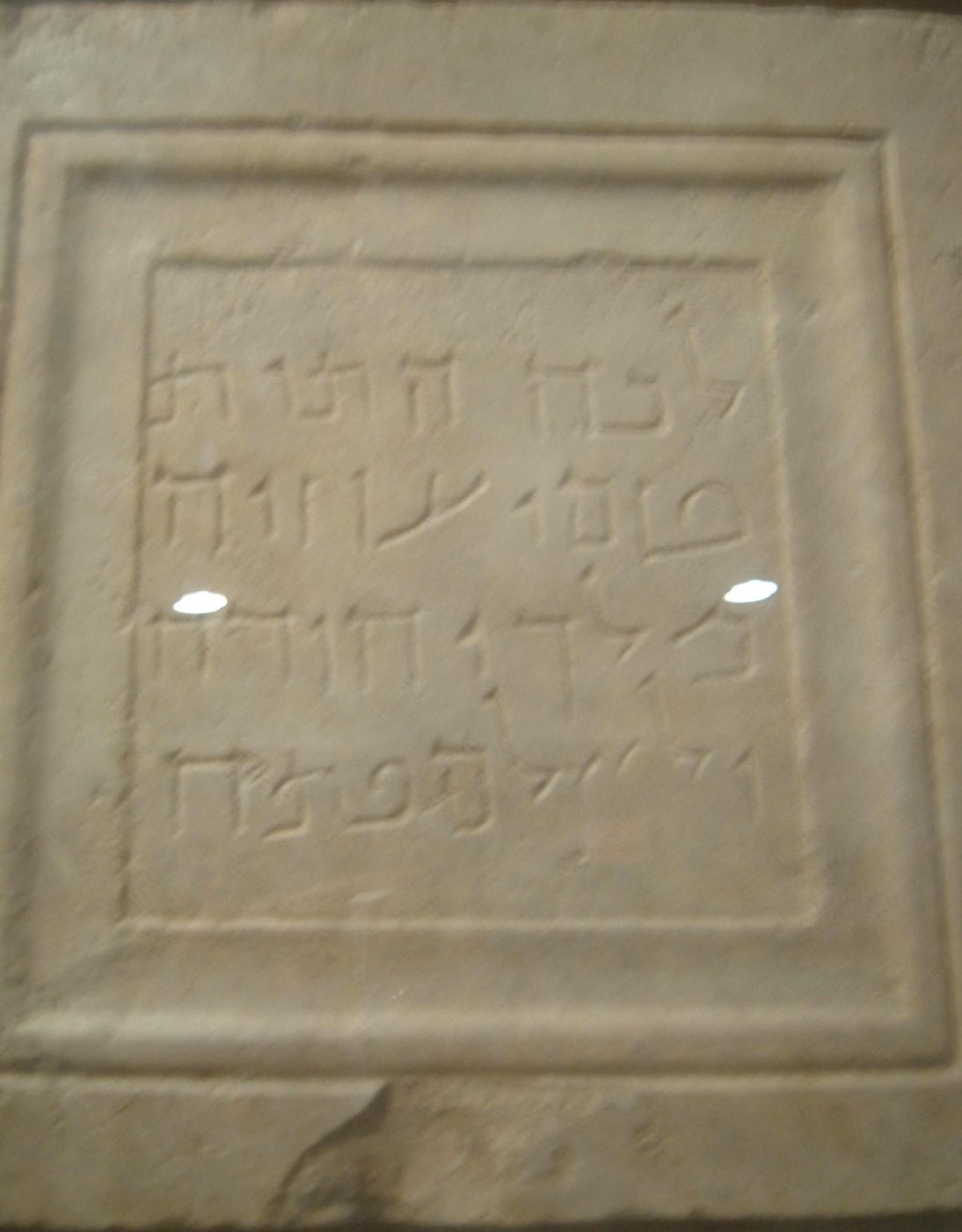 Limestone tablet incised with four lines of square Hebrew-Aramaic script.