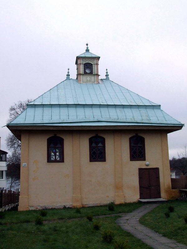 Cream-coloured wooden prayer house with teal pitched roof and octagonal cupola, the Trakai Kenesa in Lithuania
