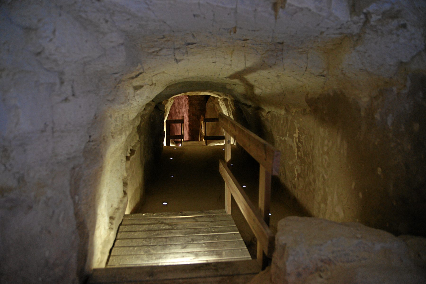Interior of the barrel-vault cistern at Tel Be'er Sheva, with stepped wooden staircase descending into the rock-cut chamber.