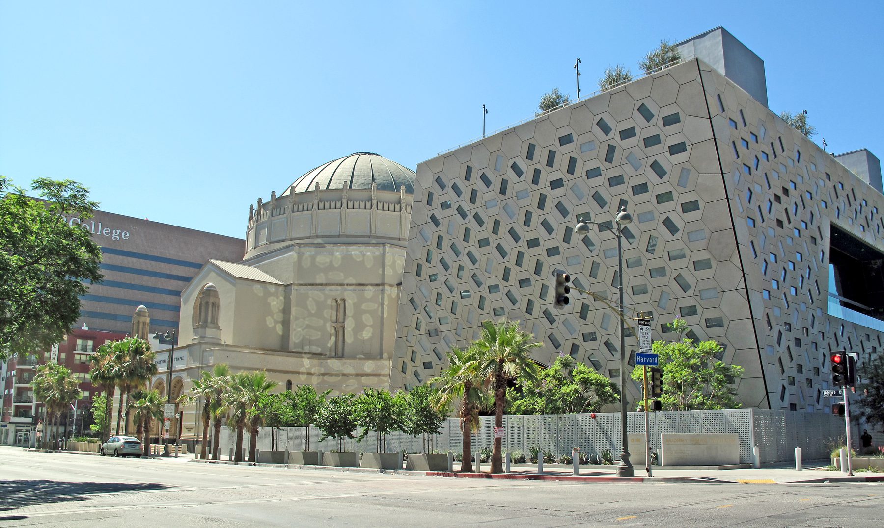 Exterior of the Wilshire Boulevard Temple showing its distinctive Byzantine dome with ribbed coffering, pale stone facade, and adjacent modern buildings.