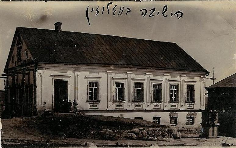 Historic photograph of the Volozhin Yeshiva building in Valozhyn, Belarus, with figures at its entrance